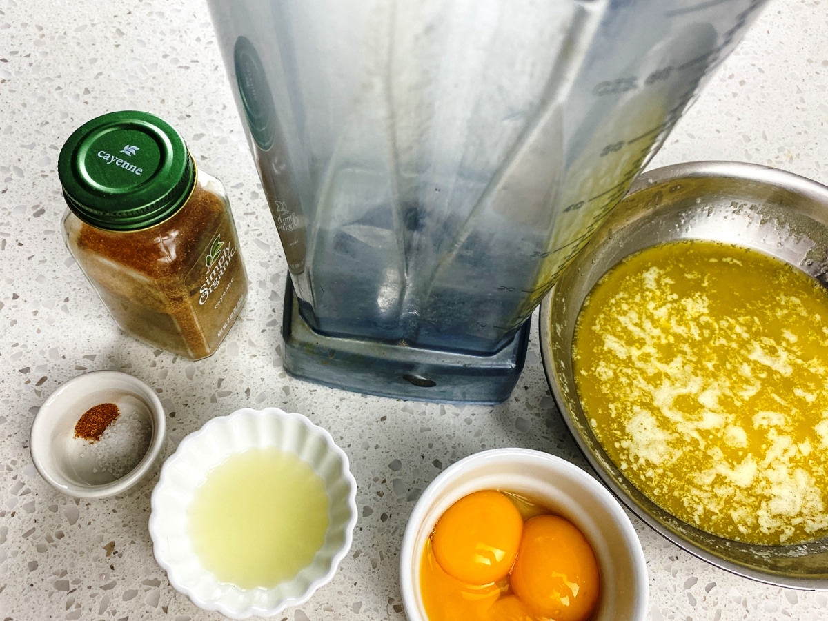 ingredients for blender hollandaise sauce including egg yolks, melted butter, lemon juice, salt, and cayenne pepper